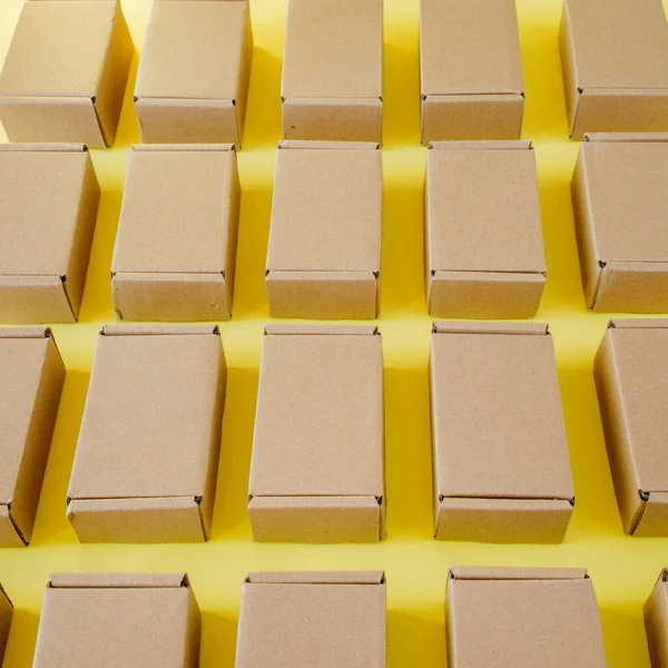 黄色の背景に多くの段ボールクラフトボックス 小包を梱包する — ストック写真