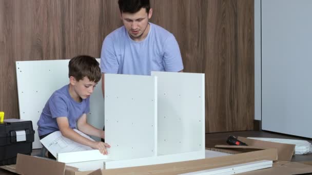 Vater Und Sohn Montieren Neue Möbel Auf Dem Boden Der — Stockvideo
