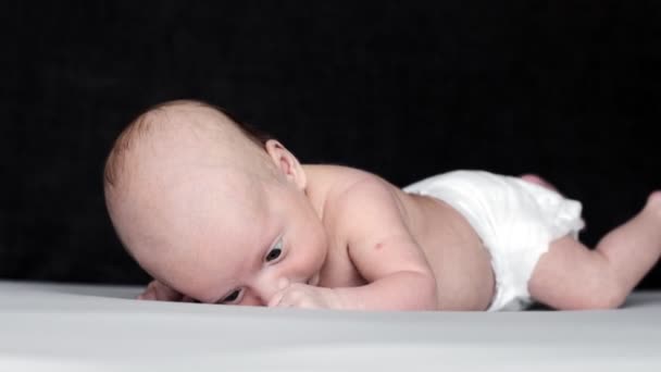 Novorozené Dítě Ležící Břiše Posteli Zatímco Sobě Pouze Plenky — Stock video