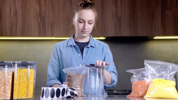女人用一个塑料盒来整理厨房的储藏室 食物产品的编排及分类 — 图库视频影像