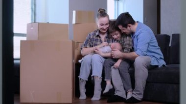 Mutlu aile babası ve çocukları yeni daireye taşınıp kutuları boşaltıyor. Modern Ev Dekorasyona Hazır