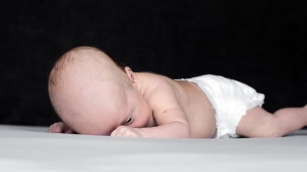 Novorozené Dítě Ležící Břiše Posteli Zatímco Sobě Pouze Plenky — Stock video