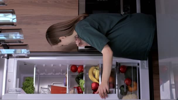 Mujer Embarazada Cerca Del Refrigerador Elige Qué Comer Entre Verduras — Vídeo de stock