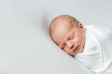 Beyaz arka planda uyuyan şirin yeni doğmuş bebeğe yakın çekim. Bakım, sevgi, mutluluk konsepti.