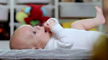 Bebek paspasa uzanıyor ve kollarını ve bacaklarını hareket ettiriyor..