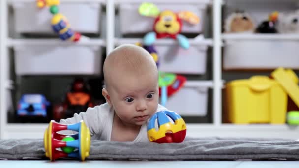 Małe Zdrowe Dziecko Bawełnianym Body Leży Brzuchu Macie Patrzy Zabawkę — Wideo stockowe