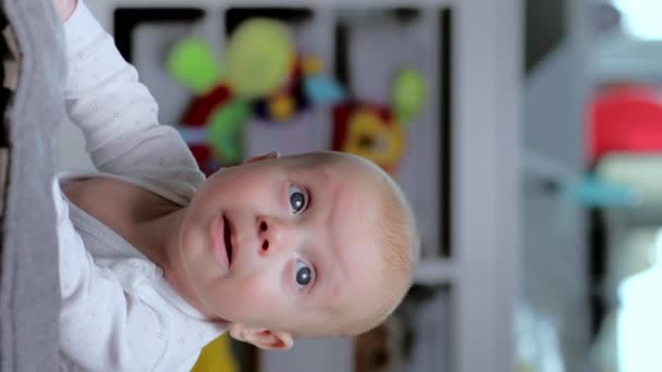 赤ちゃんは胃の上に横たわり おもちゃ 垂直ビデオを見ています — ストック動画