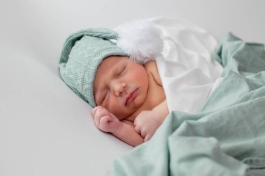 Beyaz arka planda uyuyan şirin yeni doğmuş bebeğe yakın çekim. Bakım, sevgi, mutluluk konsepti.