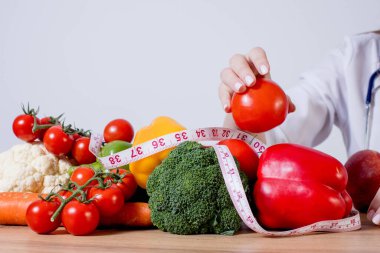 Hasta danışmanlığında meyve ve sebzelere bakan profesyonel beslenme uzmanı..