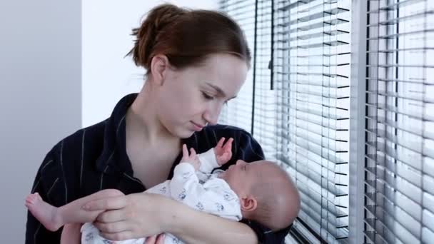 母親は腕に新生児を抱えている 若い母親は彼女の新生児を抱き 慰めています — ストック動画