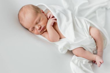 Beyaz arka planda uyuyan şirin yeni doğmuş bebeğe yakın çekim. Bakım, sevgi, mutluluk konsepti.