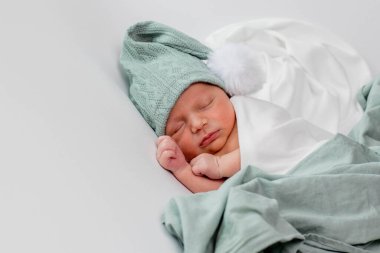 Beyaz arka planda uyuyan şirin yeni doğmuş bebeğe yakın çekim. Bakım, sevgi, mutluluk konsepti.