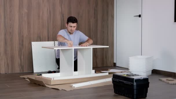 Ein Mann Sammelt Möbel Einer Neuen Wohnung Sich Selbst Zusammenstellen — Stockvideo