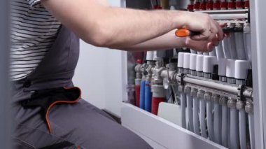 Tesisatçı işi. Ilık su yerden ısıtma sistemi için kolektör montajı.