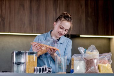 Mutfakta konteynırlarla yemek düzenleyen kadın..