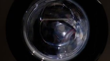 Çamaşır makinesinde renkli çamaşır yıkamak. Döndürme çok renkli şeyler cam kapıdan içeri