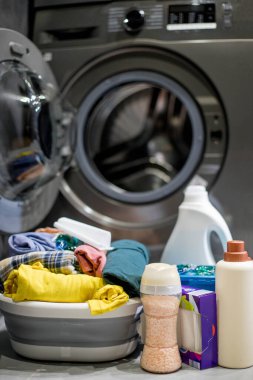 Çamaşır makinesinin yanında çamaşır deterjanı. Kirli çamaşırları yıkıyorum.