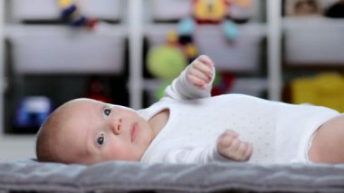 Bebek paspasa uzanıyor ve kollarını ve bacaklarını hareket ettiriyor.