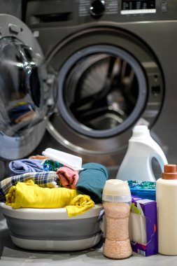 Çamaşır makinesinin yanında çamaşır deterjanı. Kirli çamaşırları yıkıyorum.