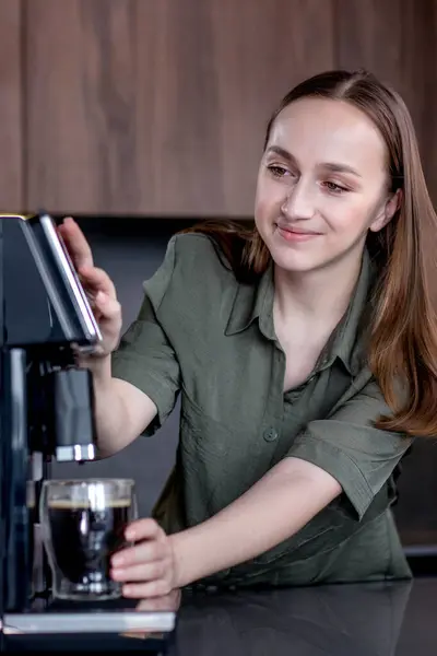 コーヒーマシンで新鮮なコーヒーを準備する女性 ホットドリンクを作るためのコーヒーブレンダーと家庭用キッチン電化製品 ストックフォト