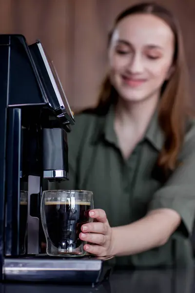 コーヒーマシンで新鮮なコーヒーを準備する女性 ホットドリンクを作るためのコーヒーブレンダーと家庭用キッチン電化製品 ストックフォト