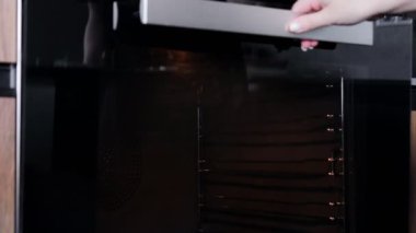 Kadın aşçı fırına kruvasan koyuyor..