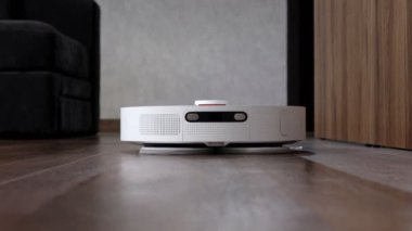 Robot elektrikli süpürge evde yerleri temizliyor. Modern akıllı temizlik teknolojisi..