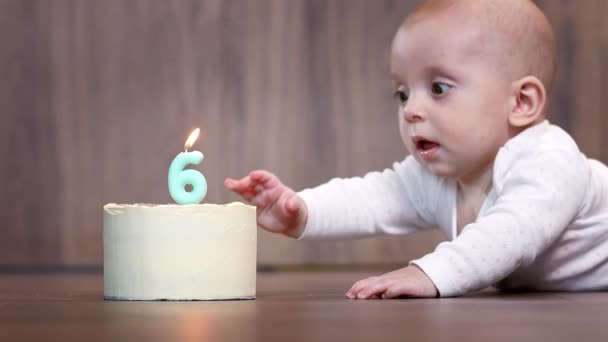 笑顔の6ヶ月の少年が美味しいケーキに向かって這っている — ストック動画