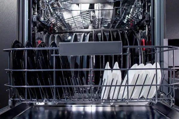 オープンな食器洗い機はキッチンで清潔な料理でいっぱいです ストック写真