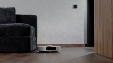 Robot elektrikli süpürge evde yerleri temizliyor. Modern akıllı temizlik teknolojisi.
