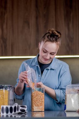 Mutfakta konteynırlarla yemek düzenleyen kadın..