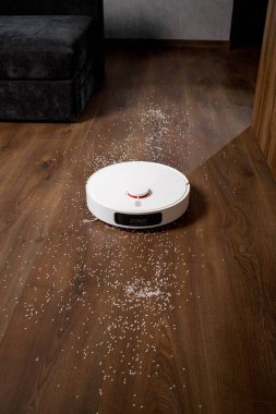 Modern robotik elektrikli süpürge dağınık pirinci yerden kaldırıyor..