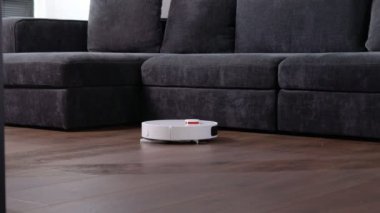 Robot elektrikli süpürge evde yerleri temizliyor. Modern akıllı temizlik teknolojisi..