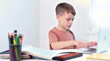 Küçük çocuk ev ödevi olarak dizüstü bilgisayar kullanıyor. Uzaklık eğitimi