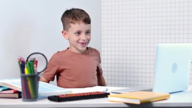 Bilgisayarlı okul çocuğu öğretmen ve sınıf grubuyla görüntülü konuşma yapıyor. Çocuk evden ders çalışıyor. Evde eğitim. Eğitim için modern aletler. Ekran zaman kontrolü. Çevrimiçi uzak öğrenim