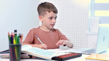 Sevimli öğrenci evde ders çalışıyor. Egzersiz kitabında yazıyor. Ödev yapıyor, evde öğreniyor..