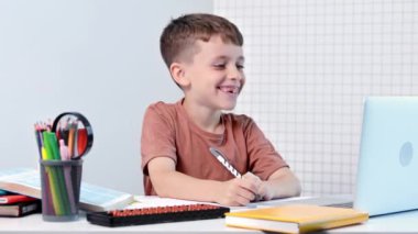 Uzaktan öğrenme çevrimiçi eğitim. Bir okul çocuğu evde dizüstü bilgisayar kullanarak ders çalışıyor. Ev uzaklığı öğrenimi.