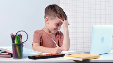 Bilgisayarlı okul çocuğu öğretmen ve sınıf grubuyla görüntülü konuşma yapıyor. Çocuk evden ders çalışıyor. Evde eğitim. Eğitim için modern aletler. Ekran zaman kontrolü. Çevrimiçi uzak öğrenim