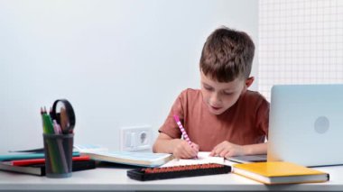 Sevimli öğrenci evde ders çalışıyor. Egzersiz kitabında yazıyor. Ödev yapıyor, evde öğreniyor..