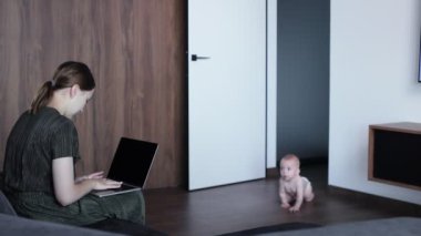 Annesi evde dizüstü bilgisayarla çalışırken küçük mutlu çocuk emekliyor. Aile hayatı kavramı.