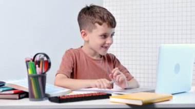 Bilgisayarlı okul çocuğu öğretmen ve sınıf grubuyla görüntülü konuşma yapıyor. Çocuk evden ders çalışıyor. Evde eğitim. Eğitim için modern aletler. Ekran zaman kontrolü. Çevrimiçi uzak öğrenim