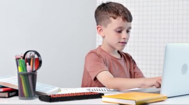 Bilgisayarlı okul çocuğu öğretmen ve sınıf grubuyla görüntülü konuşma yapıyor. Çocuk evden ders çalışıyor. Evde eğitim. Eğitim için modern aletler. Ekran zaman kontrolü. Çevrimiçi uzak öğrenim