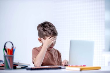 Bilgisayarlı okul çocuğu öğretmen ve sınıf grubuyla görüntülü konuşma yapıyor. Çocuk evden ders çalışıyor. Evde eğitim. Eğitim için modern aletler. Ekran zaman kontrolü. Çevrimiçi uzak öğrenim