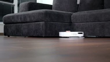 Robot elektrikli süpürge evde yerleri temizliyor. Modern akıllı temizlik teknolojisi.
