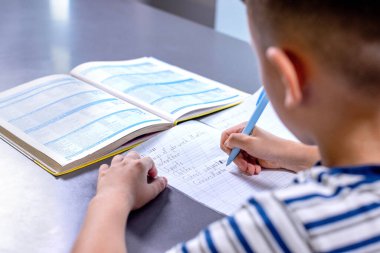 Çocuk mutfakta ödevini yapıyor..