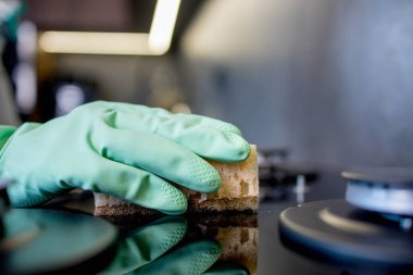 Yeşil bir lastik eldiven ver, gaz sobasını yıka. Mutfağı temizliyorum..