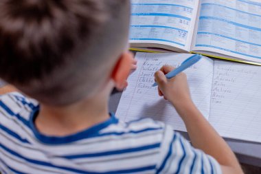 Öğrenci çocuk mutfakta ders yazıyor..