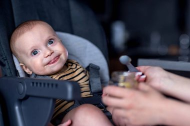 Anne küçük bebeğini mutfakta besliyor. Bebeğin ilk yemeği..