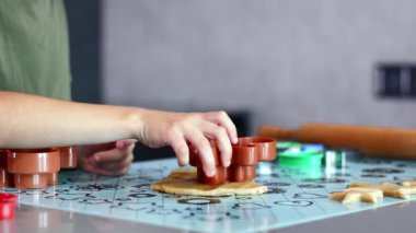 Evdeki mutfakta kurabiye keskisi ve hamur kullanarak kurabiye yapan küçük ellerin yakın çekimi..