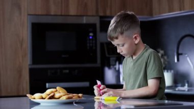 Ev mutfağında zencefilli kurabiye süsleyen tatlı çocuk.